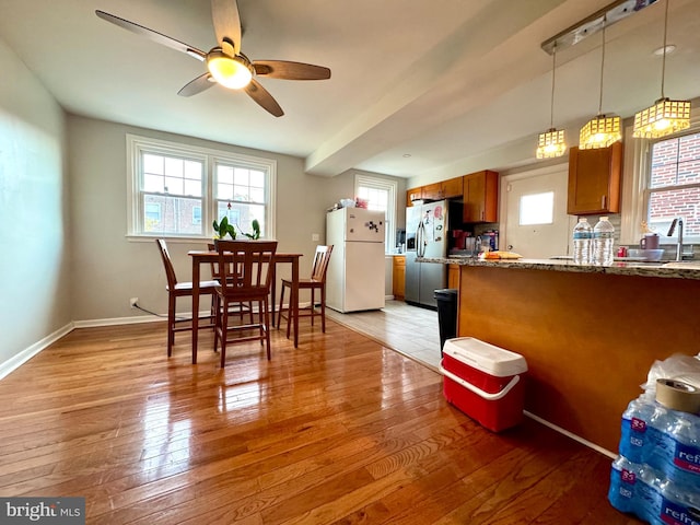 dining area with sink, light wood-type flooring, and ceiling fan