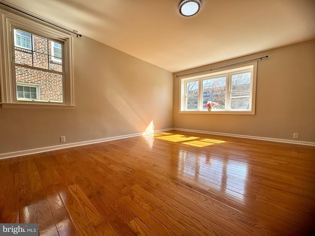 empty room featuring hardwood / wood-style flooring and baseboards