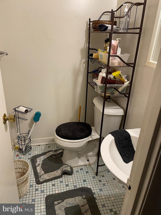 bathroom with toilet and tile patterned floors