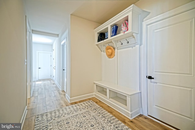 mudroom featuring light wood-style flooring and baseboards