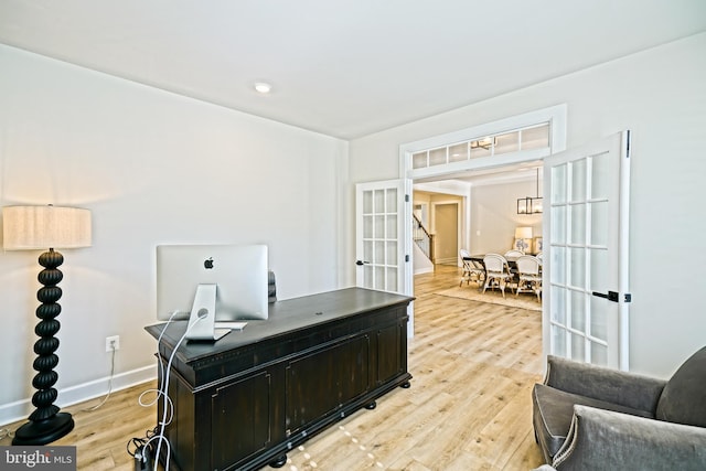 office featuring baseboards, french doors, and light wood-type flooring