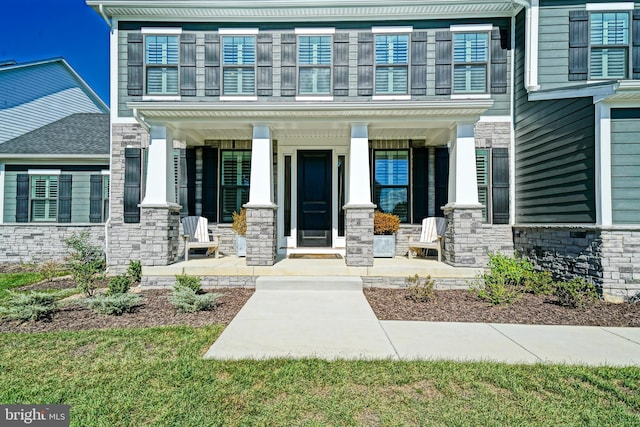 entrance to property with stone siding and covered porch