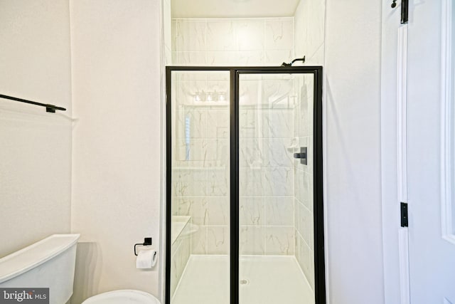 bathroom featuring toilet and a shower with door