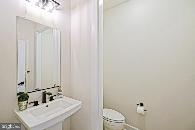 half bathroom with toilet and a sink