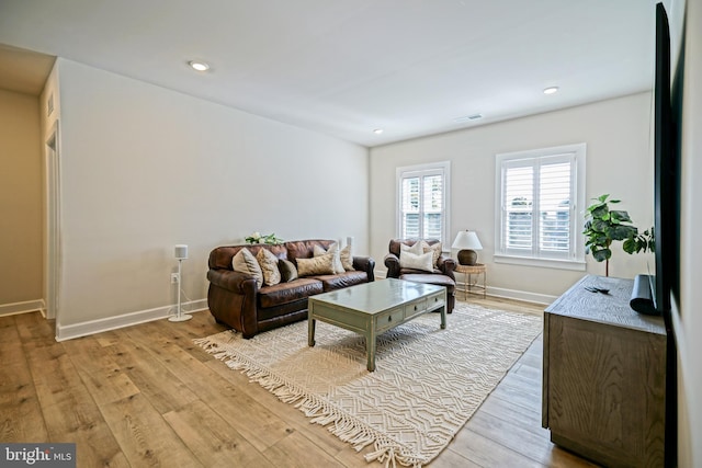 living room featuring light wood finished floors, recessed lighting, visible vents, and baseboards