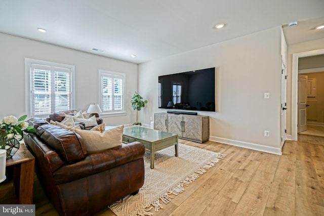 living room with baseboards, visible vents, light wood finished floors, and recessed lighting