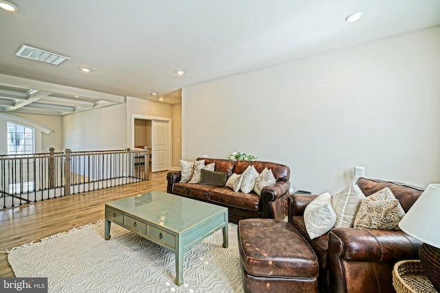 living area featuring beamed ceiling, recessed lighting, visible vents, and wood finished floors