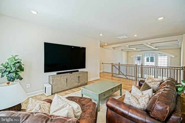 living room featuring light hardwood / wood-style floors and beamed ceiling