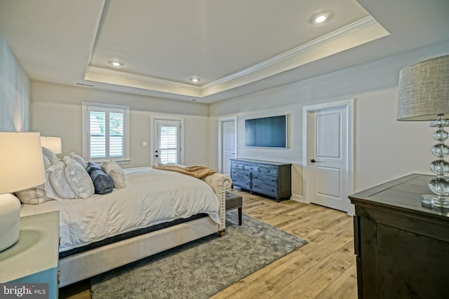 bedroom with a raised ceiling, light wood-type flooring, recessed lighting, and ornamental molding