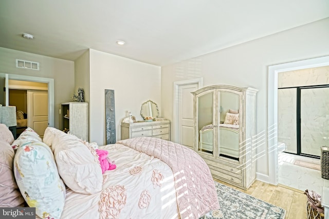 bedroom with light wood finished floors and visible vents