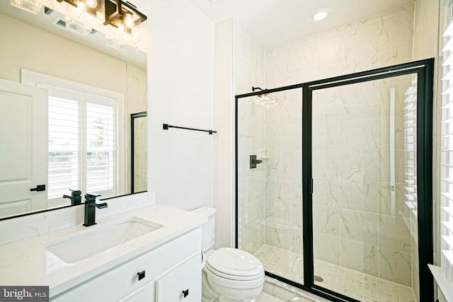 bathroom with vanity, an enclosed shower, and toilet