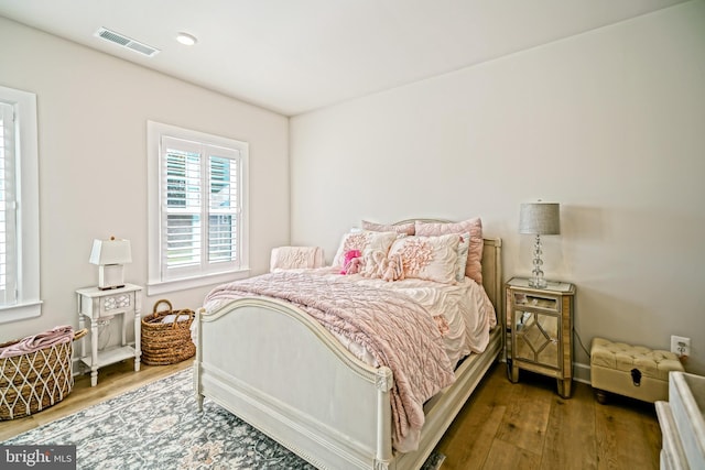 bedroom with visible vents and wood finished floors