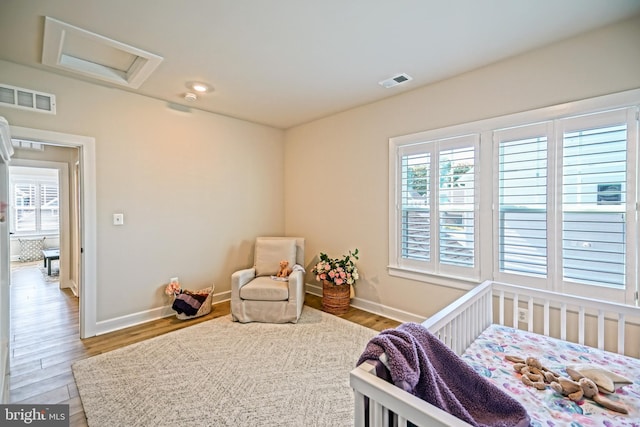 bedroom featuring attic access, visible vents, and multiple windows