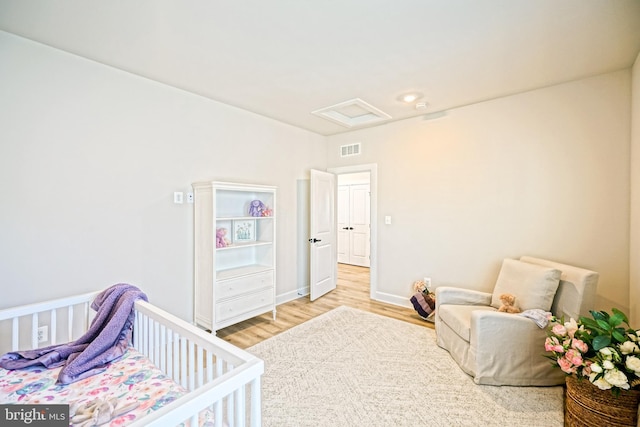 bedroom featuring attic access, visible vents, wood finished floors, and baseboards