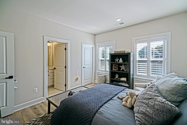 bedroom featuring light hardwood / wood-style floors and ensuite bath