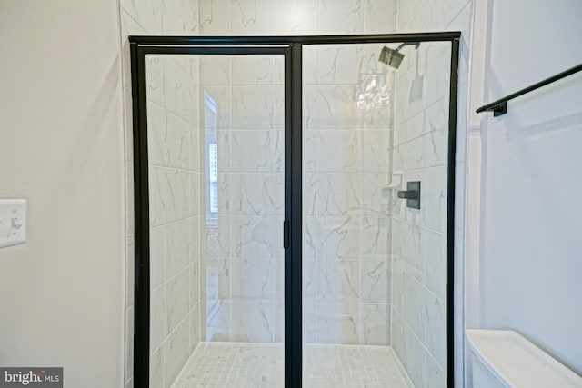 bathroom featuring toilet and an enclosed shower