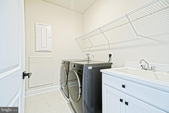 laundry area featuring washer and dryer, cabinet space, marble finish floor, electric panel, and a sink