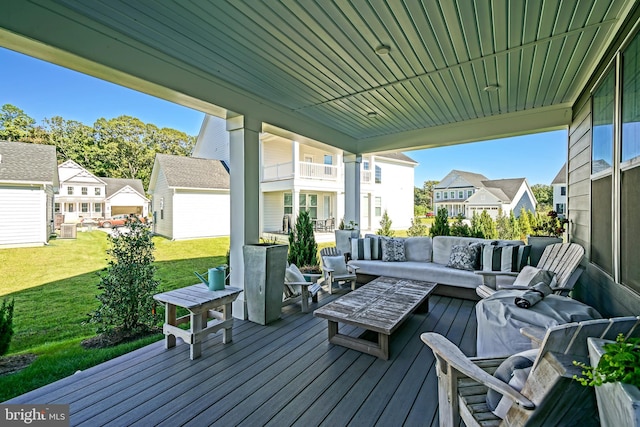 wooden terrace with an outdoor hangout area, a yard, and a garage