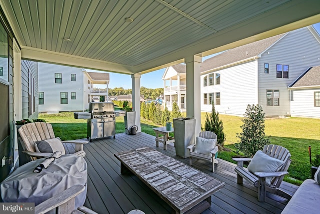 deck featuring grilling area, a residential view, and a lawn