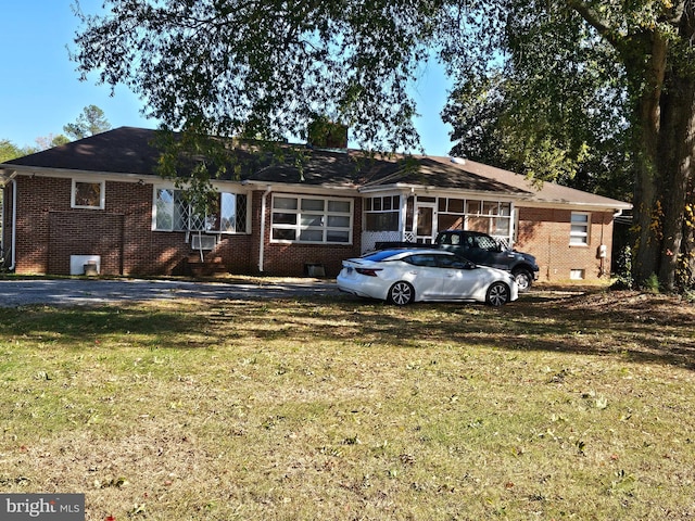 single story home featuring a sunroom and a front lawn