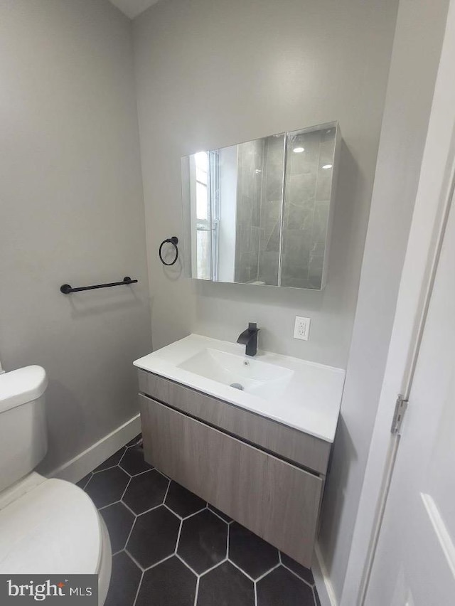 bathroom with vanity, toilet, and tile patterned flooring