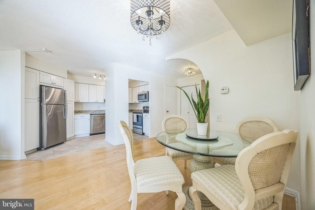 dining area featuring light hardwood / wood-style floors and a chandelier