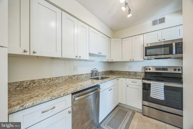 kitchen featuring white cabinetry, light stone counters, appliances with stainless steel finishes, and sink