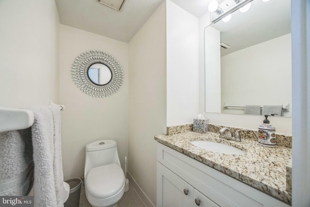 bathroom featuring toilet, vanity, and tile patterned floors