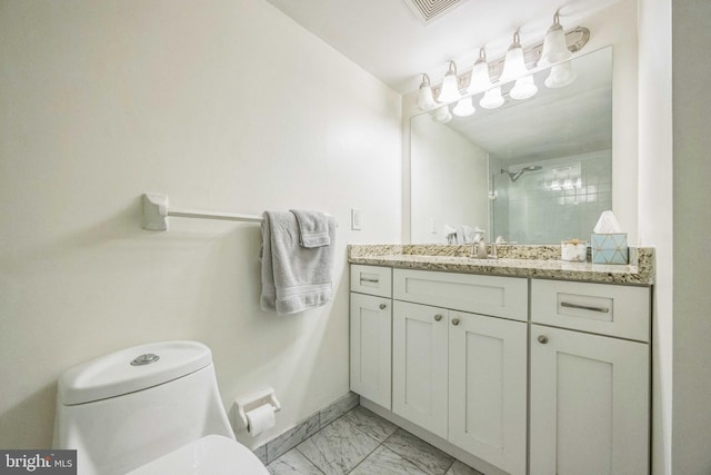 bathroom featuring vanity, toilet, and tiled shower