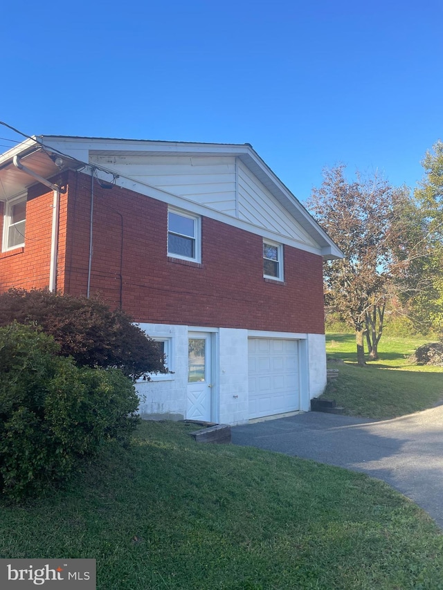 view of side of home with a yard and a garage