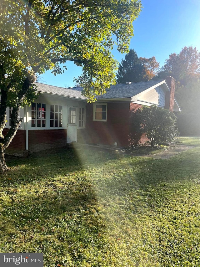 rear view of property featuring a yard