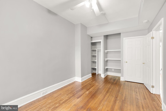 unfurnished bedroom featuring a closet, wood-type flooring, and ceiling fan