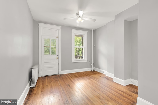 interior space featuring light hardwood / wood-style flooring, radiator heating unit, and ceiling fan