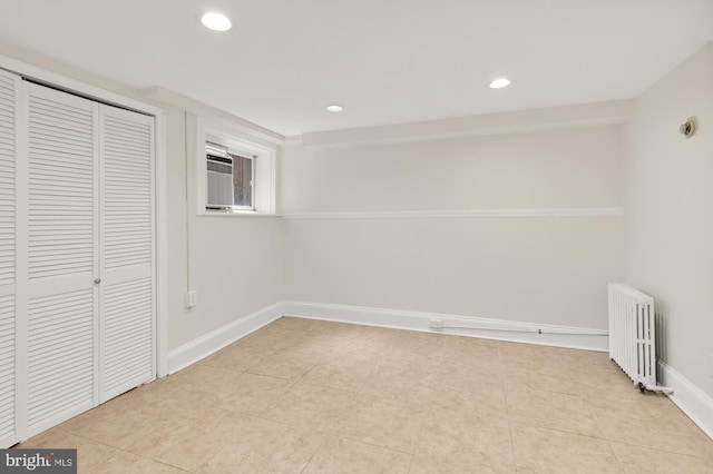 interior space featuring radiator, a closet, light tile patterned floors, and a wall mounted air conditioner