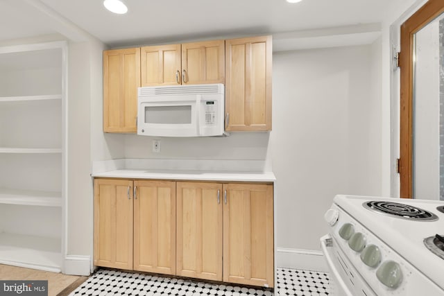 kitchen with light brown cabinetry and white appliances