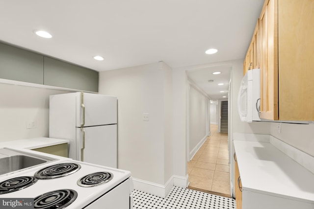 kitchen featuring light brown cabinets and white appliances