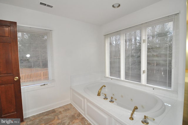 bathroom with a relaxing tiled tub