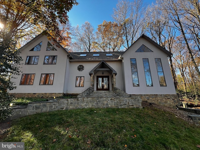 view of front of property with french doors and a front lawn