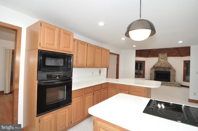 kitchen with a stone fireplace, light brown cabinets, kitchen peninsula, pendant lighting, and black appliances