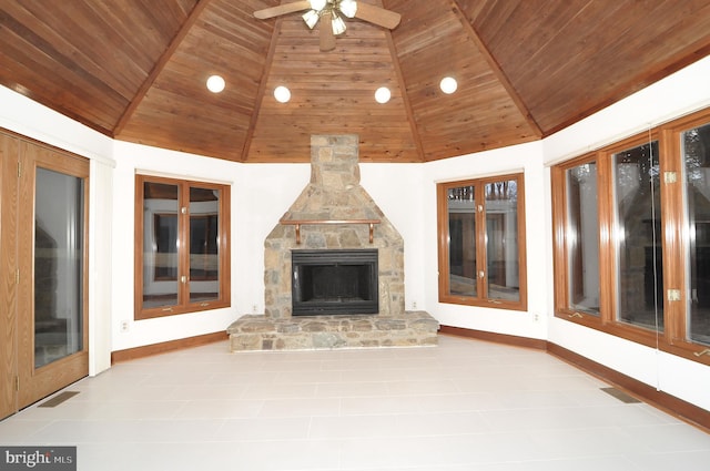 unfurnished living room with wood ceiling, a stone fireplace, high vaulted ceiling, and ceiling fan