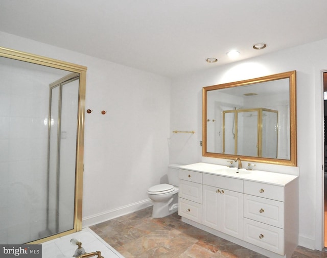 bathroom with vanity, a shower with door, and toilet