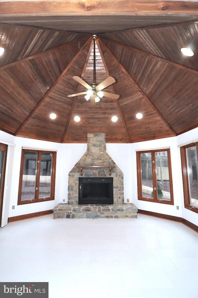 unfurnished living room featuring wood ceiling, a stone fireplace, and vaulted ceiling