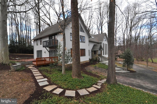 view of side of property with a wooden deck and a balcony