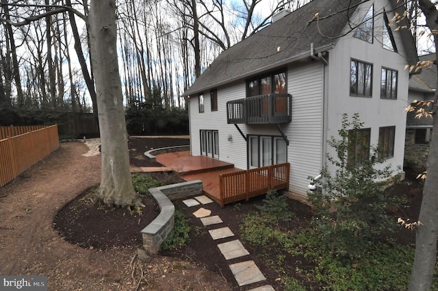 exterior space featuring a wooden deck and a balcony