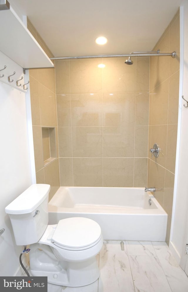 bathroom featuring tiled shower / bath and toilet