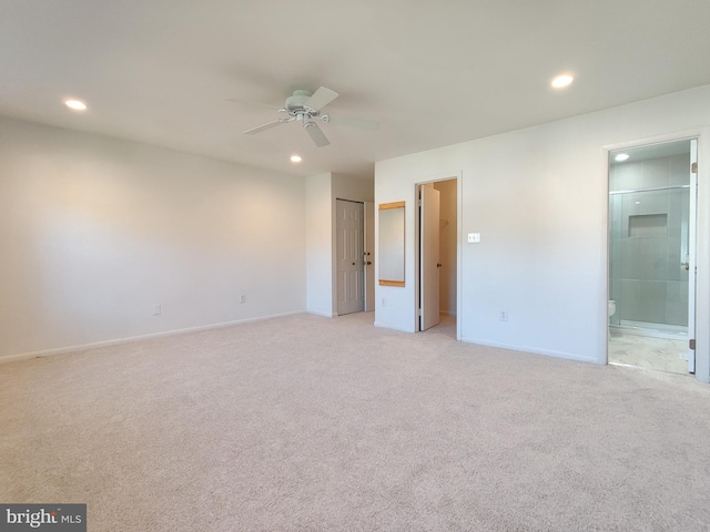 unfurnished bedroom with ceiling fan, ensuite bathroom, a closet, and light colored carpet