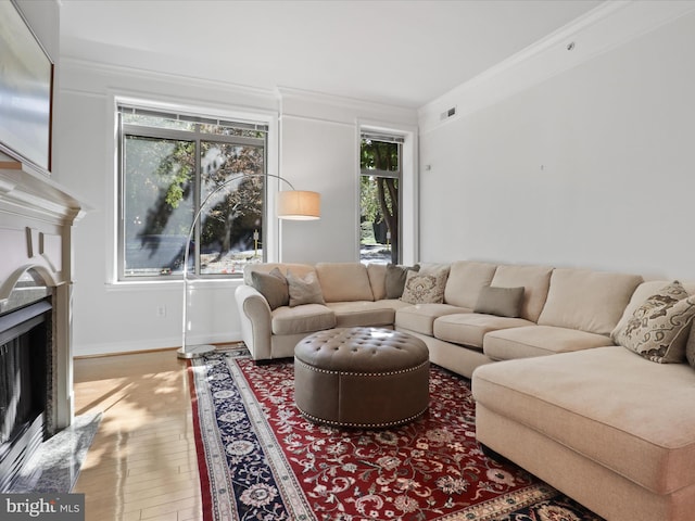 living room featuring a premium fireplace, crown molding, and hardwood / wood-style flooring