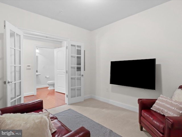 carpeted living room with baseboards and french doors