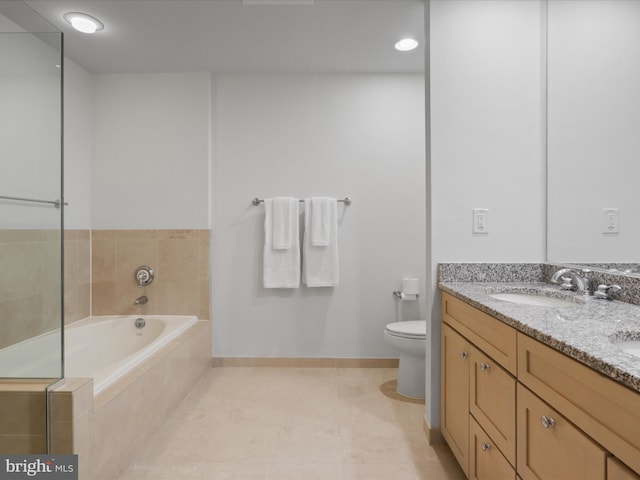 bathroom with tile patterned floors, a relaxing tiled tub, toilet, and vanity