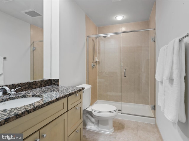 bathroom with tile patterned floors, vanity, an enclosed shower, and toilet